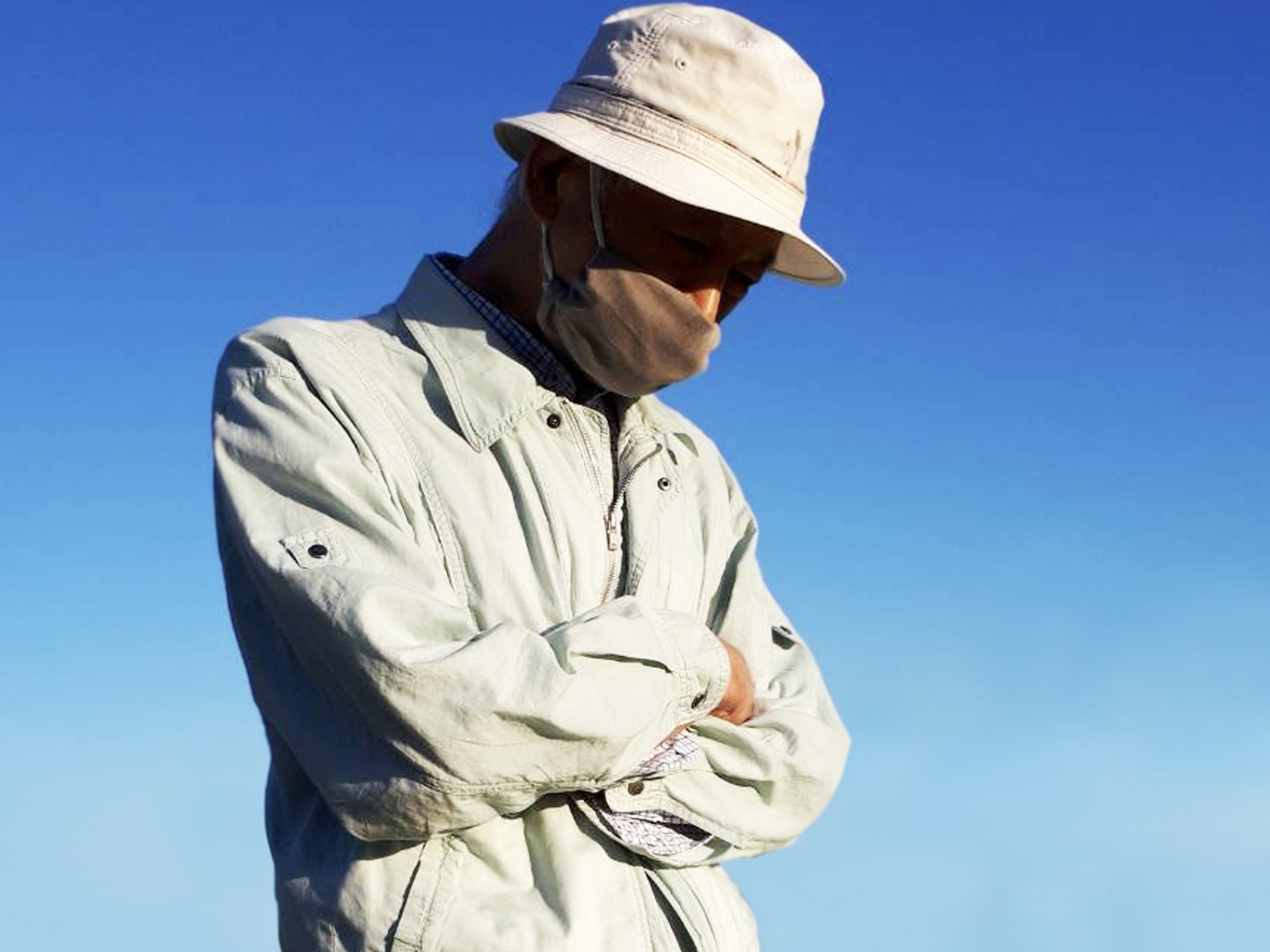 腕組をして悩む高齢農家男性