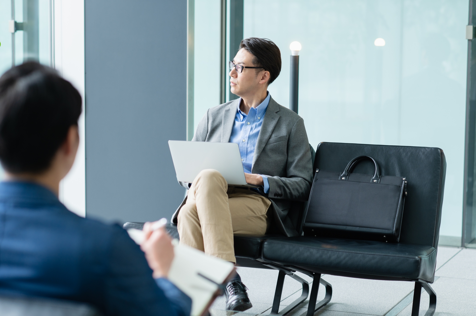 外出先でPCを開き思案中の人