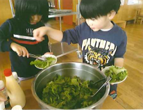 学校給食でサラダを取り分ける子どもたちの様子