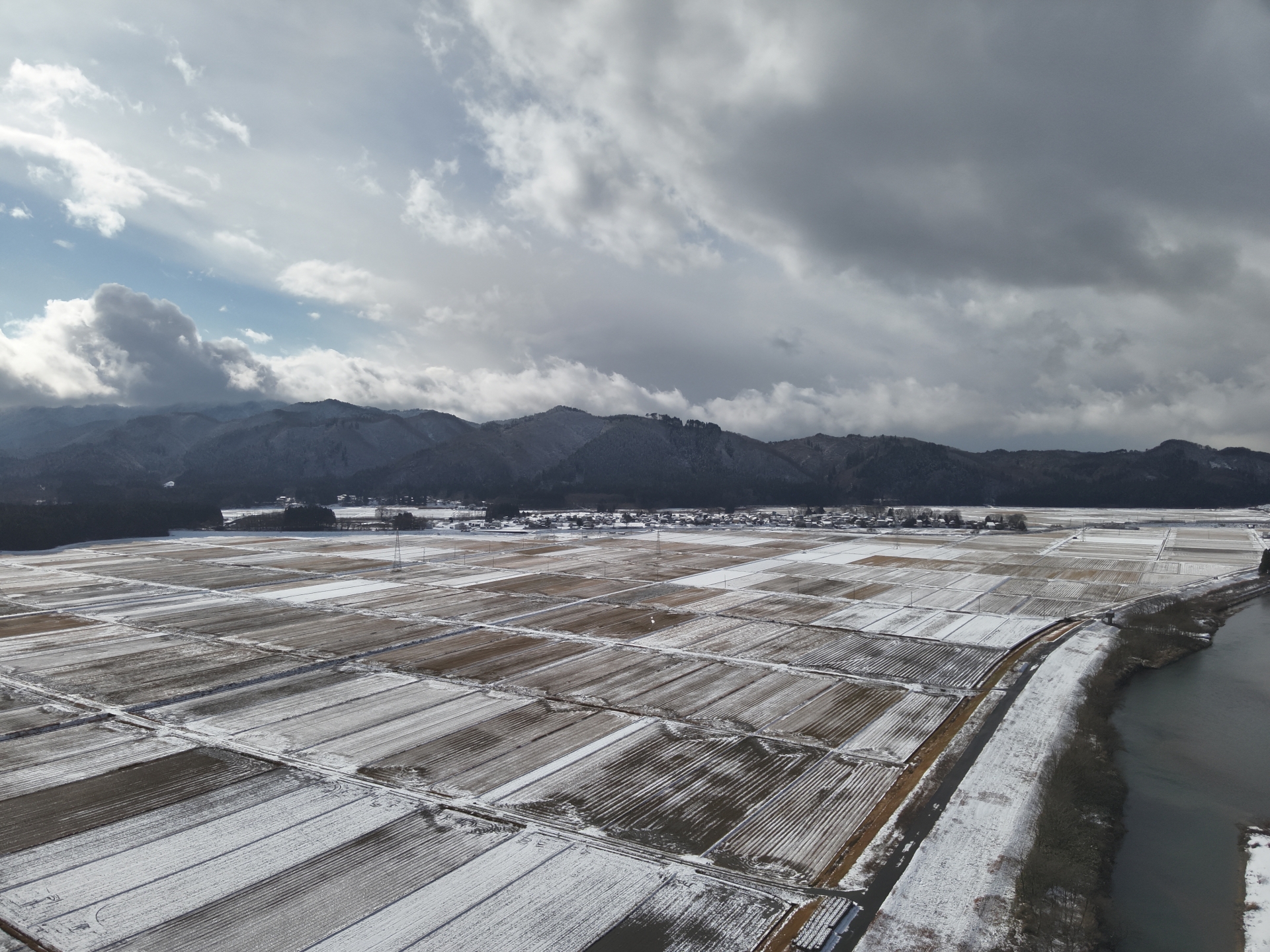 大館市の冬刈り取り後の農地に雪が積もった様子