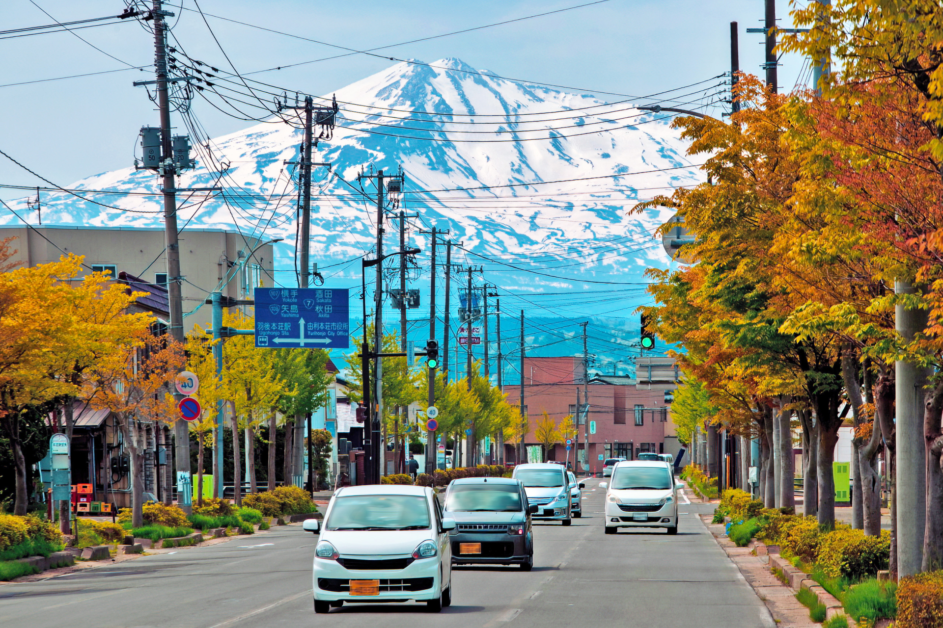 秋田県由利本荘市の街並みを彩る雪山と紅葉